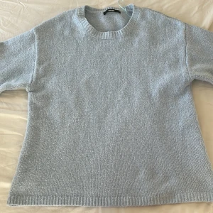 Ljusblå stickad tröja från Bik Bok - Enkel och snygg ljusblå stickad tröja från Bik Bok. Tröjan har rund halsringning, långa ärmar och ribbade muddar vid ärmslut och nederkant. 