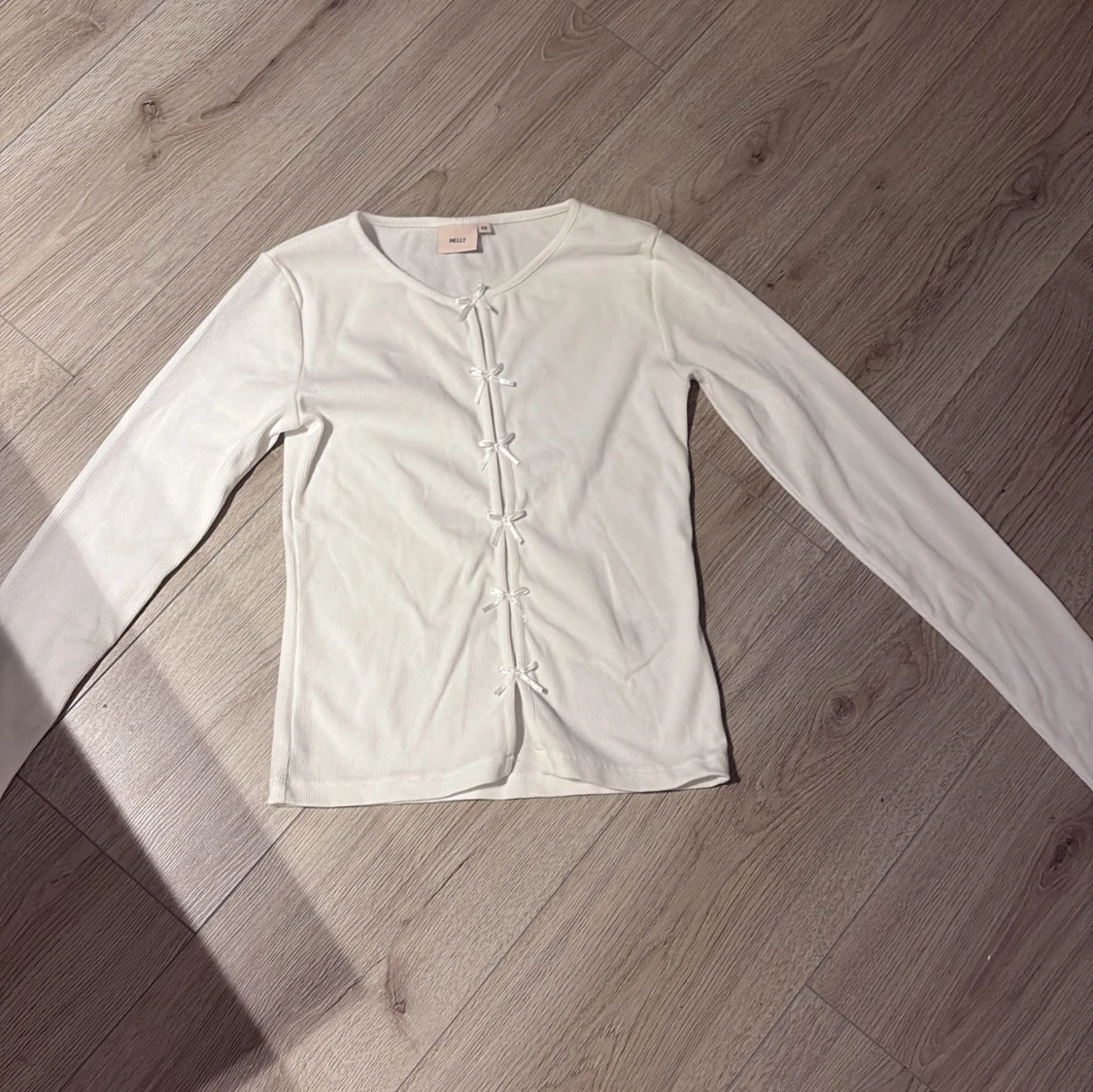 Vit ribbad topp med rosetter från Nelly