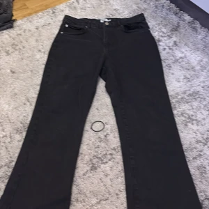 Svarta jeansbyxor från 157, storlek M  - Svarta jeansbyxor från 157 i klassisk femficksmodell. Byxorna har raka ben och normal passform, med bälteshällor och knappstängning. Perfekta svarta jeans som funkar till allt och är lätta att matcha med olika stilar.