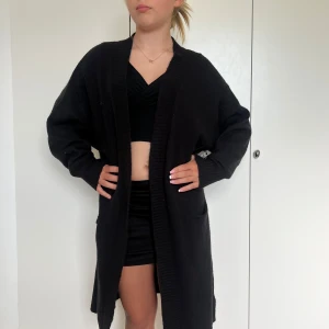 Svart lång mjuk kofta - Såå bekväm, mjuk och fin kofta från Nelly. Den är aldrig använd och prislappen/etiketten är kvar!💕