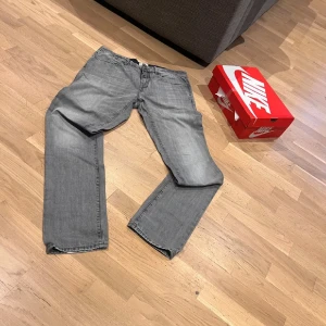 Grå jeans från Timberland, storlek 35 - Säljer ett par grå jeans från Timberland i storlek 35. Klassisk femficksmodell med dragkedja och knapp, raka ben och bälteshällor. Jeansen har en snygg tvättad look och är tillverkade i bomull. Perfekta för en avslappnad stil.
