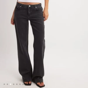 Svarta raka jeans med låg midja - Säljer dessa populära svarta jeans med låg midja och raka ben. Jeansen har klassisk knapp och dragkedja framtill samt en avslappnad passform. Perfekta till en enkel topp eller oversized kavaj för en cool look. 