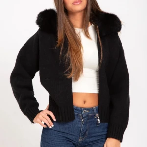 Svart stickad jacka med fuskpäls - Svart stickad jacka med dragkedja och stor huva med fluffig fuskpäls. Endast använd ett par gånger i riktigt gott skick. !Inte mina bilder!