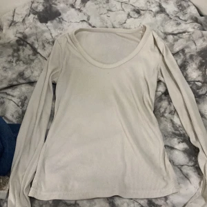 Ljusbeige ribbad långärmad tröja - En enkel och stilren ljusbeige långärmad tröja med ribbad struktur och rundad halsringning. Perfekt att matcha med jeans eller kjol för en clean look. Mjuk och skön mot huden, passar dig som gillar minimalistisk stil. Från SHEIN