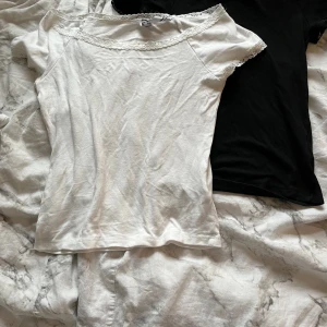 spetskantade toppar från 157 - Supersöta toppar från 157 i storlek XS med korta ärmar och spetsdetaljer längs halsringning och ärmslut. Tunn och mjuk bomullskänsla, perfekt för dig som gillar en enkel men gullig stil. Passar dig som vill ha en feminin touch på outfiten.