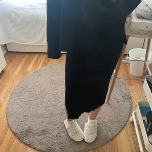 Svart långkjol med asymmetrisk kant - Svart långkjol med snygg asymmetrisk nederkant. Materialet känns mjukt och stretchigt, vilket gör den bekväm att bära hela dagen.