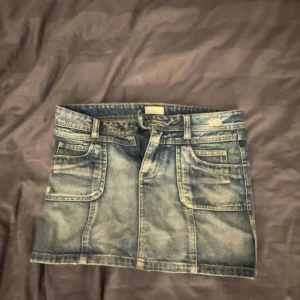 Blå jeanskjol med fickor - Säljer en lågmidjad kort blå jeanskjol. Passar perfekt för en ute kväll eller nu till hösten med strumpbyxor 💕säljer pågrund av den är för stor💕