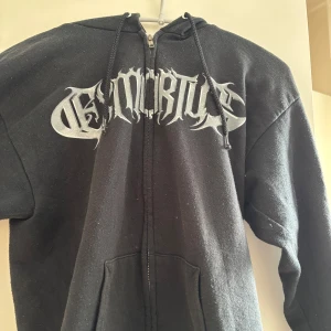 Svart Exmortus zip up - Svart zip up hoodie från Exmortus med tryck fram och bak. Den har luva! Är lite nopprig där av priset, men har fortfarande mycket att ge! Skriv om du har frågor!💓
