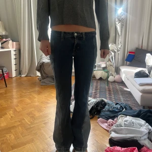 Blå bootcut jeans med låg midja - Coola blå bootcut jeans med ljusare jeans detaljer längs utsidan av benen. Köpa här på Plick men endast andvända fåtal gånger och säljs inte längre på weekday, köpta för 500 kr.