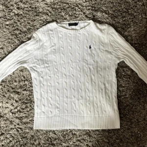 Vit kabelstickad tröja från Polo Ralph Lauren✅ - Säljer en vit kabelstickad tröja från Polo Ralph Lauren med klassisk rund hals och diskret logga broderad på bröstet. Passa på nu när de är gratis frakt och priset går alltid att diskutera 🤩🙌✅