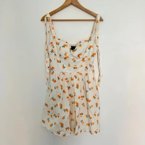 Vit kortklänning med apelsinmönster från Zara  - Supersöt vit kortklänning med apelsinprint och knytband på axlarna. Ändast använt 1 gång!!🍊🍊