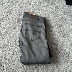 Grå skinny jeans Tiger of Sweden - Snygga grå jeans från Tiger of Sweden i modellen skinny med klassisk femficksdesign och smal passform. Jeansen är tillverkade i mjuk denim och har en stilren look som passar till sneakers eller boots. Perfekt för dig som gillar en modern och clean stil.