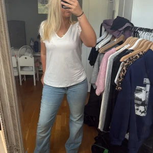 Vit blus med spetsärmar  - Säljer en vit topp från SHEIN i storlek S. Toppen har v-ringning och korta ärmar med snygga spetsdetaljer som ger en extra touch. Materialet är mjukt och lätt.