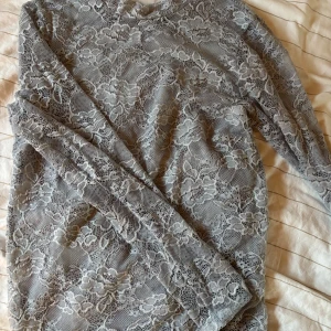 Ljusblå spetstopp - Supersnygg ljusblå topp i spets med blommigt mönster.Perfekt för dig som gillar att sticka ut med coola material och mönster. Passar dig som vill ha något extra till din outfit. Storlek S i fint skick! 