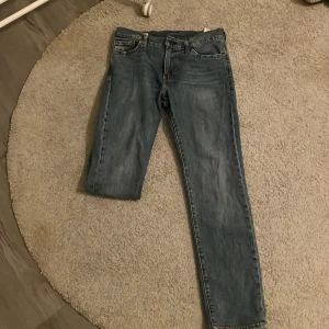 Levi's 511 blå jeans straight fit - Säljer ett par Levi's 511 jeans i klassisk blå tvätt med straight fit. Jeansen har fem fickor, bälteshällor och Levi's ikoniska läderpatch bak. Passar dig som gillar en tidlös look med lite smalare ben. Perfekt till sneakers eller boots. Hör av er vid funderingar🤗