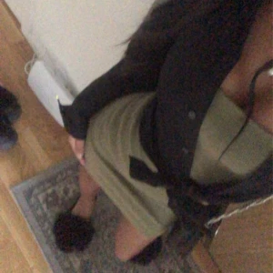 Olivgrön kortklänning - Säljer en olivgrön kortklänning med tight passform och v-ringad hals. Man kan köpa skjortan till om man vill det. Skriv för fler bilder. 