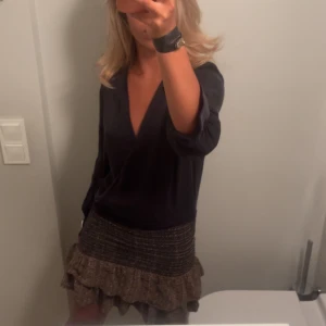 Isabel marant kjol - Supersöt kort brun kjol med volanger och strukturerad yta. Kjolen har en ribbad midja och dubbla volanglager som ger en cool och lekfull vibe. Perfekt att styla med en stickad tröja eller boots för en trendig look. Från isabel marant i fint skick