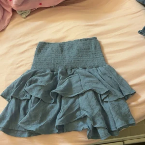 Blå volangkjol med smock - Tunn/ luftig blå volangkjol. Aldrig använd