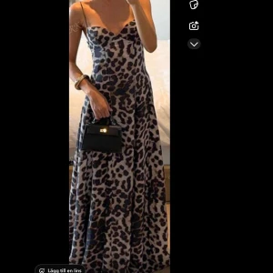 Leopardmönstrad långklänning - Säljer en snygg långklänning med leopardmönster i svart och beige. Materialet är mjukt och och stretchigt upptill. Använd 2 gånger, ingen dragskedja