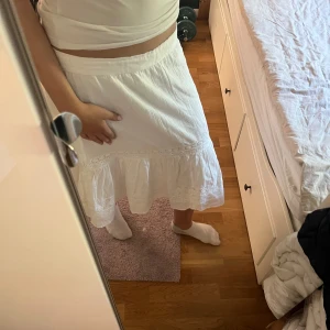 Vit volangkjol från Odd Molly - Superfin vit kjol från Odd Molly med volangkant och broderade detaljer. Kjolen har en avslappnad passform och är gjord i ett lätt bomullstyg, perfekt för varma dagar. Snygg midja och romantisk känsla, passar perfekt till sommaren. Det syns ej på bilderna men där bak på kjolen uppe i midjan är det resår för stretch. Jag är storlek S i vanliga fall och kjolen är för stor i midjan för mig så den är nog storlek M eller L