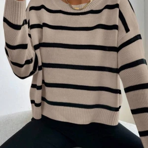 Beige och svart randig stickad tröja - Snygg beige stickad tröja med svarta horisontella ränder.