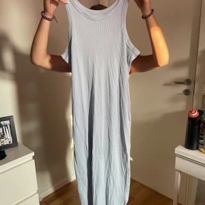 Ljusblå ribbad långklänning - Säljer en ljusblå långklänning med ribbad struktur. Klänningen är ärmlös. 