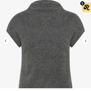 Grå polotröja med kort ärm - Snygg grå polotröja med korta ärmar och mjuk stickad känsla. Perfekt för lager-på-lager och passar till både jeans och kjol. Tröjan har en enkel design med hög krage och är tillverkad i ett stickat material som känns skönt mot huden.