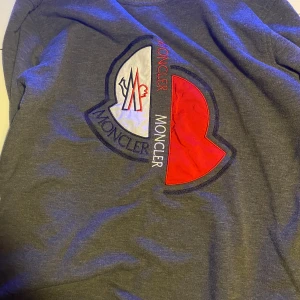 Grå sweatshirt från Moncler med stor logga - Säljer en grå sweatshirt från Moncler, den passar s/m. Bra kvalité förutom att etiketten inuti är lite lös