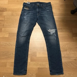 Diesel jeans - Snygga blå jeans från Diesel, modell Thavar. De har en slim passform med raka ben och slitna detaljer på framsidan för en cool look.