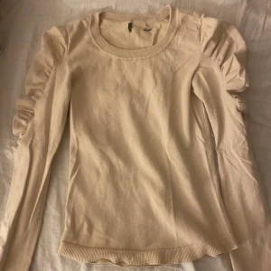 Beige tröja med volangärmar💕 - Säljer en jättesöt beige tröja med långa volangärmar. Tröjan är i bra skick och har inga defekter💓
