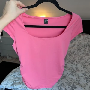 Rosa topp från Shein - Säljer en snygg rosa topp från Shein i storlek S. Toppen har korta ärmar och en rund halsringning. Perfekt för en färgglad look! Önskar du veta exakta mått? Tveka inte att höra av dig!