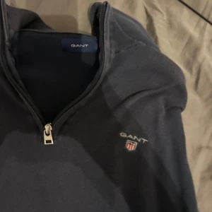 Mörkblå tröja med dragkedja från GANT - Nypris 2000 köpt för 1700 i deras butik köpt 2024 använda 5-10 gånger har dock tecken på uttvättning darför det låga priset men fotfarande en fin tröja att använda