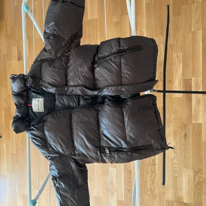 Moncler Brun dunjacka  - Säljer en snygg brun dunjacka från Moncler. Jackan har en pufferdesign med dragkedja och knappar framtill. Den är långärmad och perfekt för kyligare väder. Klassisk och stilren look som passar till mycket. Vill få den sålt snabbt så skicka ett prisförslag 