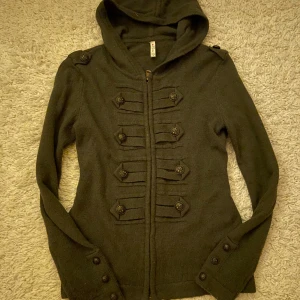 Grön huvjacka från Fishbone - Snygg grön huvjacka från Fishbone med dekorativa knappar och dragkedja framtill. Storlek S