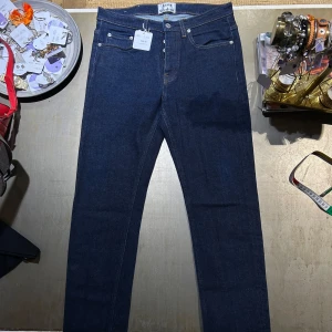Acne Studios Mörkblå jeans  - Nypris: ca 4000kr. Snygga mörkblå jeans från Acne Studios med knappgylf. Perfekta för en stilren look.