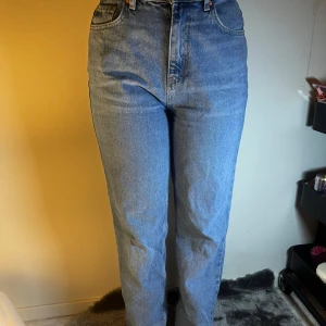 Blå högmidjade jeans - Snygga blå jeans med hög midja och klassisk femficksdesign. Perfekta för en avslappnad stil. De har en rak passform som ger en tidlös look.