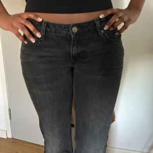 Weekday jeans - Snygga svarta jeans från weekday med bootcut-stil och låg midja. Perfekta för en avslappnad look. De har klassisk femficksdesign och knappar i midjan. Jag är 177 och den passar bra i längden. Priset kan diskuteras