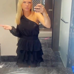 Svart oneshoulder klänning - Jättte snygg svart oneshoulder klänning med volanger. Den är från Gina i storlek S. Men passar även XS. Tveka inte på att höra av dig om du vill ha fler bilder.🌸💞