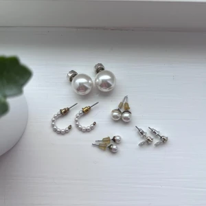 Set med pärlörhängen - Ett set med olika pärlörhängen. Inkluderar stora vita pärlörhängen, små pärlörhängen med guldfäste, halvcirkelformade pärlörhängen och små silverfärgade örhängen med snöflingeliknande detaljer. Perfekt för att mixa och matcha till olika tillfällen. Jag lägger örhängena i plastfickan som finns på sista bilden, så de inte utsätts för skada under leverans.