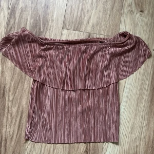 Rosa offshoulder topp - Säljer en snygg rosa offshoulder topp med plisserade detaljer. Toppen har en luftig passform och är perfekt för varma dagar. Den är tillverkad i ett lätt och bekvämt material. Perfekt för fest 💓