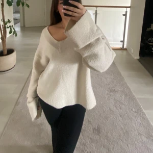 Beige stickad tröja med v-ringning - Mysig cremevit stickad tröja med v-ringad hals och långa ärmar. Från Gina Tricot. För lat för att fixa nopprorna där av priset😅 Annars bra skick!