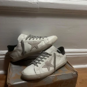 Golden goose skor - Tja! Säljer nu ett par extremt feta golden goose skor med en distressad design. Har använt en gång i princip helt nya, men det negativa är den skadade boxen som man kan se.Har tyvvär heller inget kvitto 🧾🥲 köptes för omkring 3 månader sen och har stått på hyllan! Ställ gärna frågor angående skorna. Storlek: 42EU
