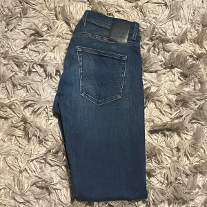 Blå jeans från Replay - Snygga blå jeans från Replay i modellen Grover. De har en klassisk femficksdesign med en diskret tvätt för en modern look. Perfekta för en avslappnad stil.