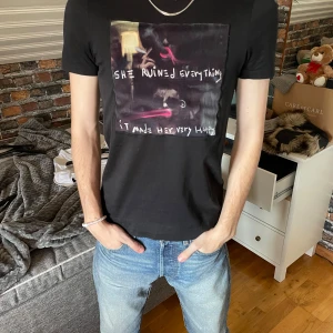 Svart t-shirt med tryck från Limitato - Snygg svart t-shirt från Limitato med ett konstnärligt tryck på framsidan. Perfekt för dig som vill ha något unikt i garderoben. Kortärmad och i en normal passform.