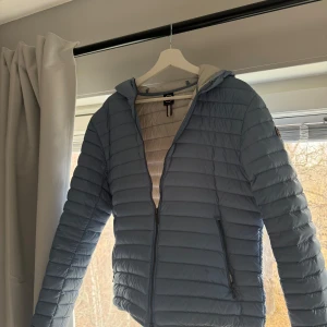 COLMAR vår jacka HERR - Säljer en snygg blå dunjacka från COLMAR. Jackan har en dragkedja framtill och en praktisk huva. Perfekt för årstiden  och har en stilren design. Använd cirka 2-3 gånger, inga defekter och tags finns vid intresse!