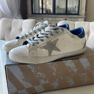 !AUKTION! Golden Goose Super-Star Sneakers - Vit/Blå - ÄKTA! - ÄKTA Golden Goose model Super-Star sneakers i utmärkt kvalité! Använda men fortfarande väldigt bra kvailté. Perfekt style döe snygga skor eller kollections! !AUKTION!