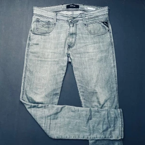 Ljusgråa jeans från Replay - Snygga ljusgråa jeans från Replay med klassisk femficksdesign och diskret logga på fickan. Jeansen har en rak passform och är perfekta för en avslappnad stil. De är tillverkade i ett bekvämt denimtyg som ger en skön känsla hela dagen.