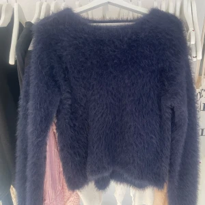 Mörkblå fluffig tröja från H&M - Säljer en supermjuk och fluffig mörkblå tröja från H&M. Perfekt för kyliga dagar när du vill vara både varm och stilren. Tröjan har en enkel design med långa ärmar och en rund halsringning. Ett måste för garderoben! 💙