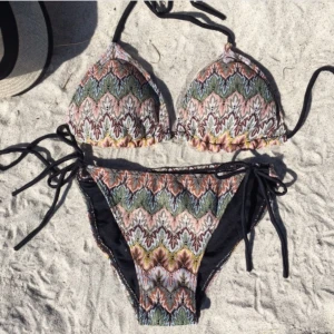 Mönstrad bikini med knytband - Säljer min bikini från design by si jag fick i födelsedagspresent för att den var för liten😣endast testad! Överdelen har knytband runt nacken och ryggen, medan underdelen har knytband på sidorna för justerbar passform.💞