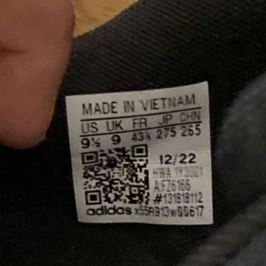 Svarta och vita sneakers från Adidas - Säljer ett par klassiska svarta sneakers från Adidas med vita detaljer och snörning. Skorna har de ikoniska tre ränderna på sidan och en vit sula. Perfekta för en avslappnad stil.